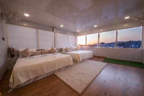 a large bedroom with two beds and a large window at Perfectstayz Homes I Luxury Penthouse in Haridwār