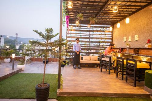 a man is standing on a balcony of a restaurant at Perfectstayz Homes I Luxury Penthouse in Haridwār