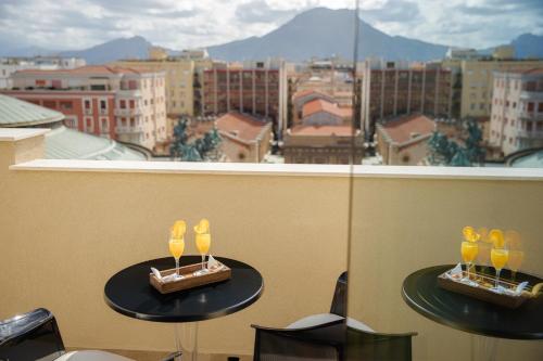 two tables with wine glasses on them in front of a window at Hotel Politeama in Palermo