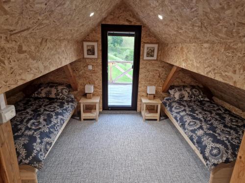 2 camas en una habitación con ventana en Vineyard cottage Vinska grajska kašča, en Mirna