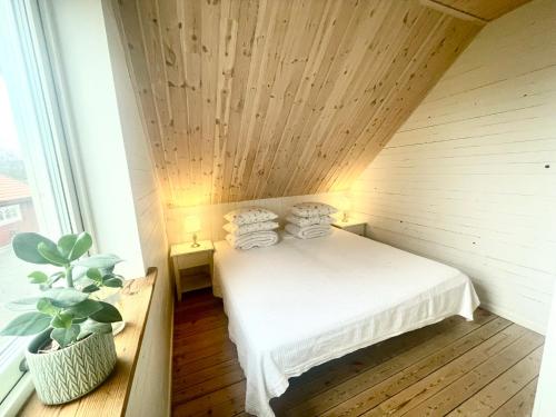 Cama en habitación con techo de madera en Lägenhet för större sällskap nära Gekås i Ullared en Vessigebro