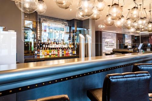 a bar in a restaurant with a counter and chairs at Premier Inn München Airport Ost in Oberding