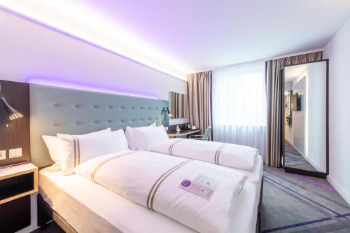 a hotel room with two beds and a mirror at Premier Inn München Airport Ost in Oberding
