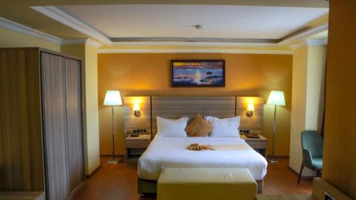una camera d'albergo con un grande letto e due lampade di Holiday Hotel Addis Ababa ad Addis Abeba