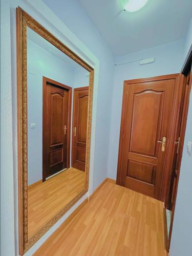 an empty room with a mirror and wooden doors at La Maresía in Cudillero