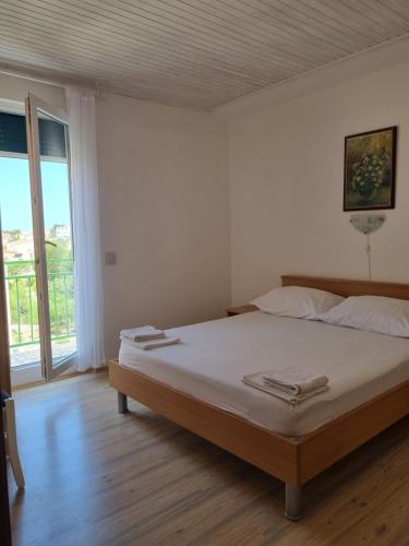 ein Schlafzimmer mit einem Bett und einem großen Fenster in der Unterkunft APARTMANI TONI POCE 2 in Primošten