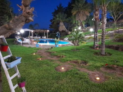 a backyard with a swimming pool at night at Luxury b&b Le Rocce in Villasmundo