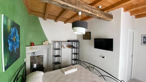 ein Wohnzimmer mit einem Bett, einem TV und einer Decke in der Unterkunft B&B Gronda Via Vandelli in Massa