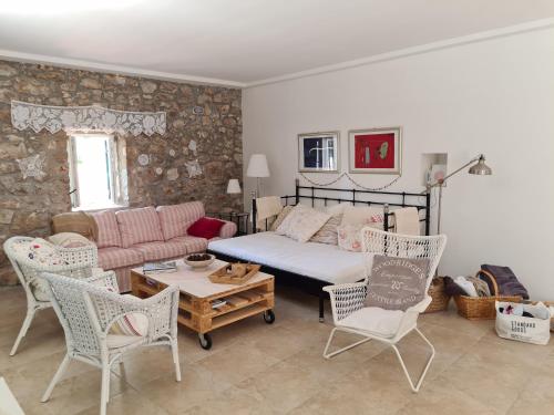 a living room with a bed and a couch and chairs at Villa stone house in Ugljan