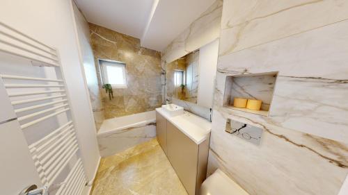 een badkamer met een wastafel, een toilet en een bad bij Deventer Residence VRT in Sibiu