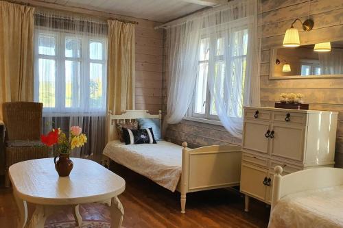 Un dormitorio con 2 camas y una mesa con flores. en Authentic homestead over 100 years old, en Kėdainiai
