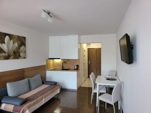 a living room with a couch and a table at Apartamenty Planeta 105, 108 Mielno in Mielno