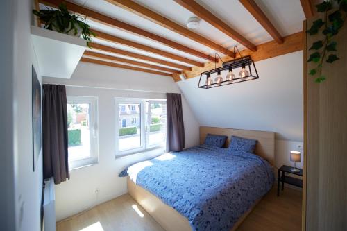a bedroom with a bed and two windows at Apartment with a view and parking in Brecht