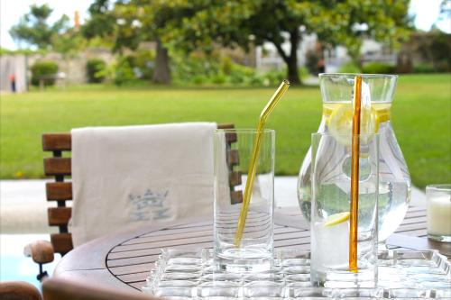 a table with two glasses and a candle on it at HOTEL BOUTIQUE VILLA DEL MARQUÉS in Muros de Nalón