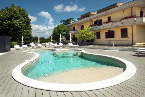 a swimming pool with chairs and a building at Hotel Ristorante Dante in Torgiano