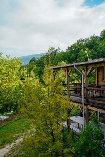 a wooden bridge over a river with a picnic table at Ferma Albanik in Këlcyrë