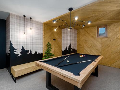 Apartamenty Górski Prestige في بيالكا تاترزانسكا: طاولة بلياردو في غرفة مع جدران خشبية