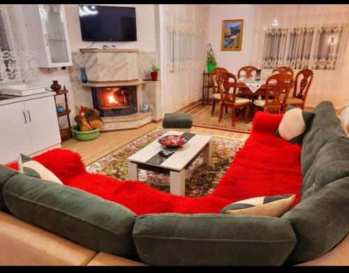 a living room with a couch with a red rug at Villa Goliku in Peshtan