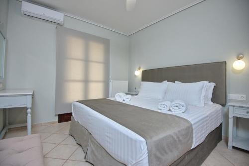 1 dormitorio con 1 cama grande y toallas. en Elpida Apartments, en Votsi