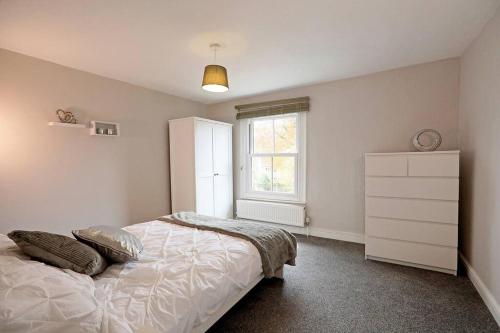 1 dormitorio con 1 cama con tocador y ventana en The Rosary Rest en Norwich