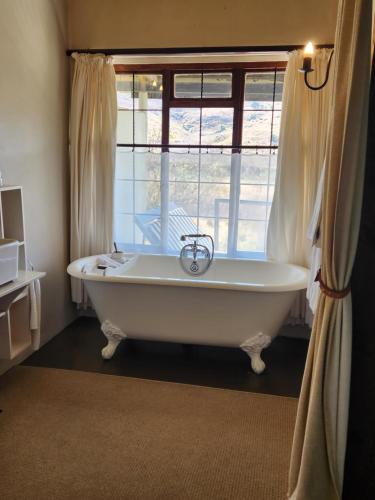 a bath tub in a room with a window at Cleopatra Mountain Farmhouse in Fort Nottingham