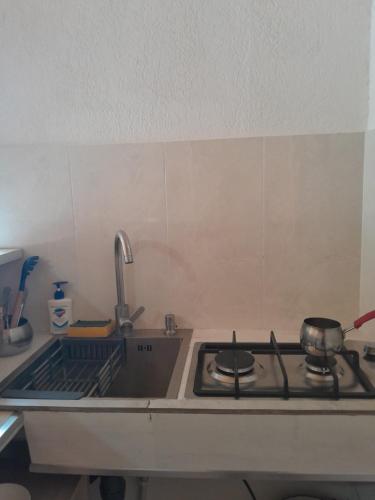 a kitchen counter with a stove and a sink at Cozy cabine in Stepantsminda