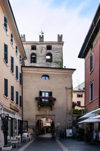 a building with a clock tower on top of it at Le Giare Apartments Garda in Garda