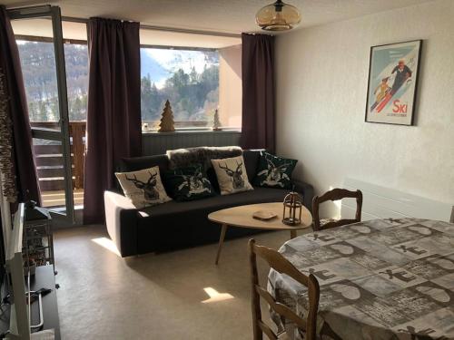 a living room with a couch and a table at 7 couchages et bébé au pied des pistes in Besse-et-Saint-Anastaise