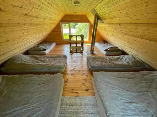 a room with four beds in a wooden cabin at Paluküla Saunas and Glamping in Paluküla