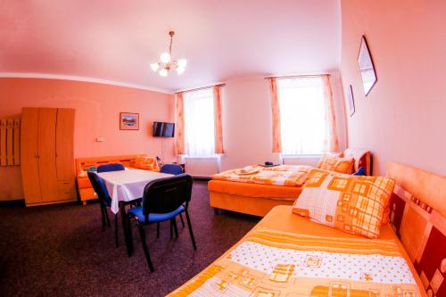 a bedroom with two beds and a table and chairs at Alexandra in Svoboda nad Úpou