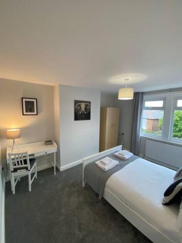 a bedroom with a large bed and a desk at Storey Apartment in Woodhorn