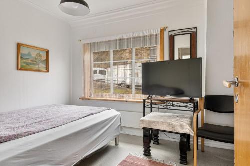 a bedroom with a bed and a desk and a window at Tysso Apartment in Tveit