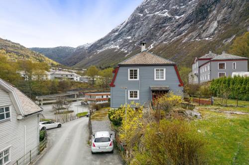 a house and a car parked on a street with a mountain at Tysso Apartment in Tveit