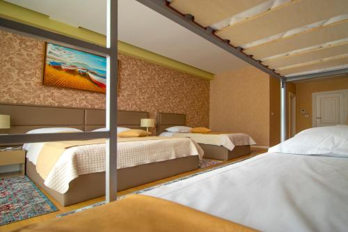 NBT Hotel Reps في Kukës: غرفة نوم بسريرين ولوحة على الحائط