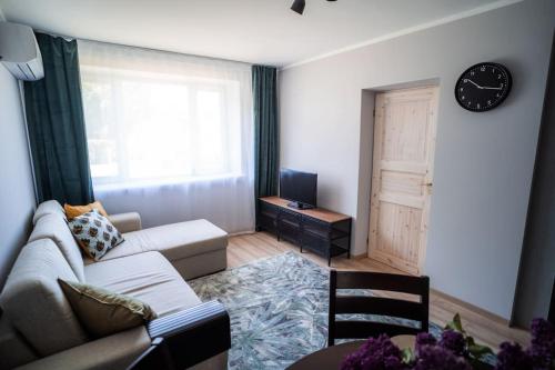 uma sala de estar com um sofá e um relógio na parede em Cozy apartment in the city center of Kärdla em Kärdla