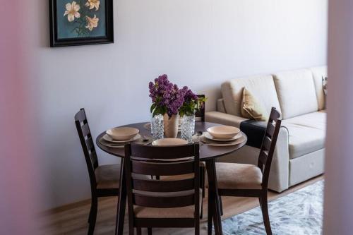 a dining room table with chairs and a couch at Cozy apartment in the city center of Kärdla in Kärdla