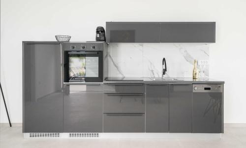 a gray kitchen with a sink and a stove at Rooftop House Vodice in Vodice