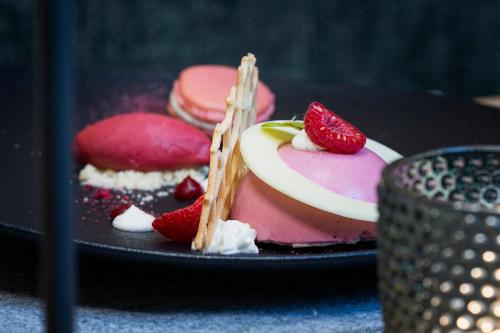 a black plate with a dessert with strawberries on it at Sepp & Hannis Suiten im Dorf in Neustift im Stubaital