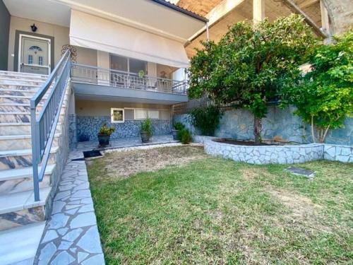 a house with a staircase and a yard with grass at Studio Cleopatra in Kanali
