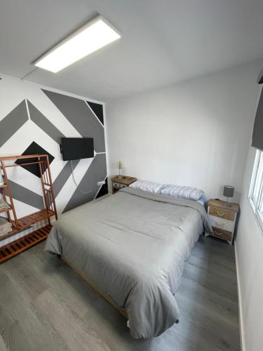 1 dormitorio con 1 cama con pared a rayas en Habitación junto el mar y la naturaleza, en Ojén