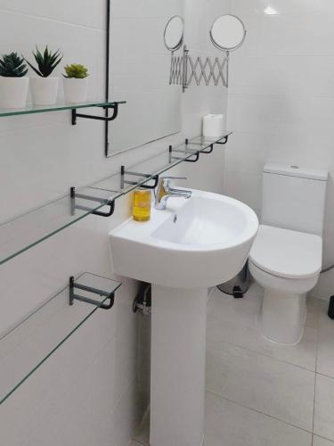 a white bathroom with a sink and a toilet at 1st Floor 1st Class Pool View Apt. in Paphos