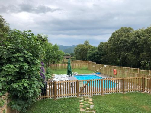 a fence around a swimming pool in a yard at Can Gich Espacio Rural in Celrá