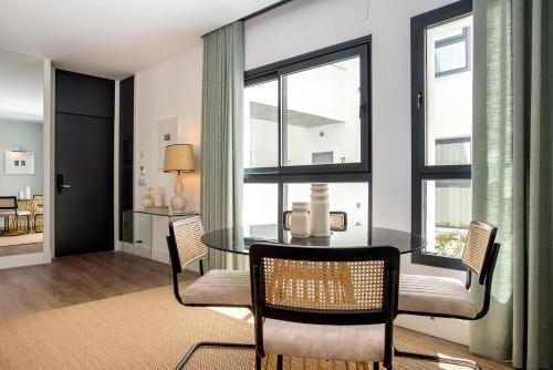 a dining room with a glass table and chairs at Genteel Home Betis 67 in Seville