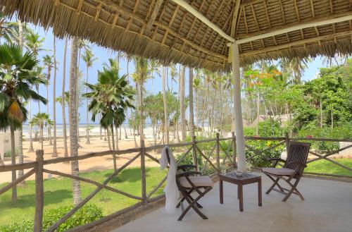 a porch with chairs and a view of the beach at Diamonds Mapenzi Beach in Kiwengwa