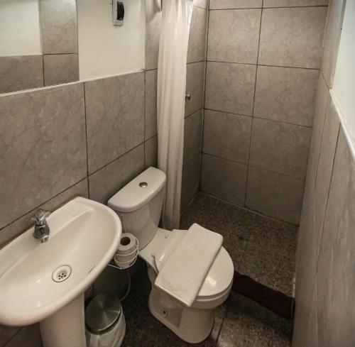 a bathroom with a white toilet and a sink at Magic Cusco in Cusco