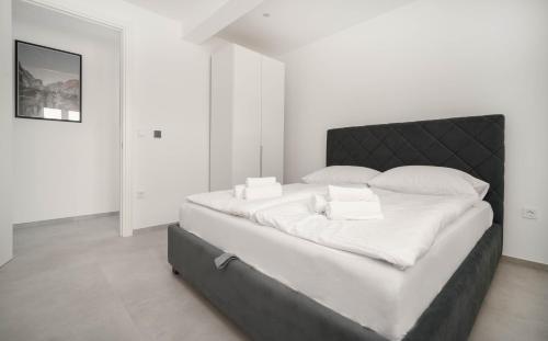 una camera da letto bianca con un grande letto con lenzuola bianche di Rooftop House Vodice a Vodice