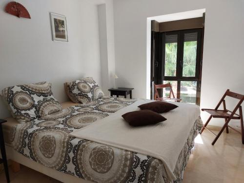 1 dormitorio con cama con almohadas y ventana en Azahar, en Alicante