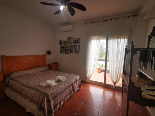 1 dormitorio con 1 cama y ventilador de techo en Casa Luz, en Málaga