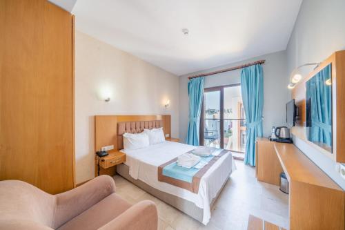 a hotel room with a bed and a desk and a tv at Majeste Hotel Bodrum in Bodrum City