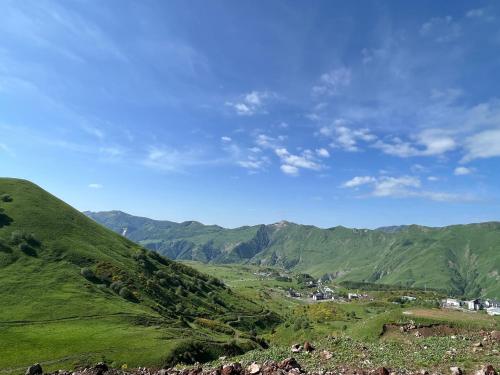 グダウリにあるTwins #144 New Gudauri with Mountain Viewの山々を背景に広がる緑の丘の景色